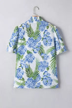 White blouse with blue hydrangea and green palm leaf print featuring short flutter neck short sleeve and striped patchwork details