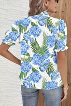 White blouse with vibrant blue hydrangea green palm leaf striped patchwork and ruffled neck short sleeve design