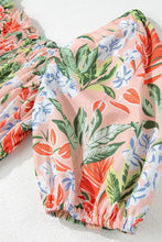 Pastel floral print off-shoulder blouse with ruffled sleeves on peach background