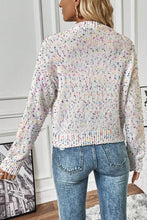 White speckled knit cardigan with long sleeves, ribbed collar and floral print