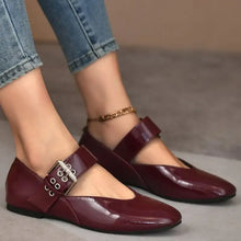 Burgundy patent leather round toe flats with buckle, chain, and eyelet details