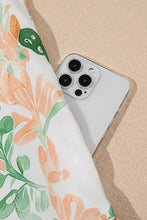 White iPhone 13 Pro with triple camera on floral romper set