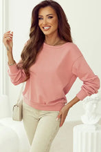 Woman in bow round neck long sleeve sweatshirt, beige jeans, white bag