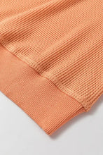 Peach V-neck long sleeve waffle knit top with orange texture and ribbed cuffs