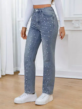 Light-wash denim pearl embellished high waist straight jeans with white pearl studs along legs and pockets