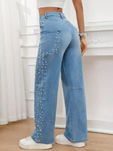 Light blue denim pearl embellished wide leg jeans with high waist and vertical pearl studs on outer seams