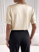 Cream pearl trim satin bodysuit with short puffed sleeves and pearl-buttoned cuffs in a trim satin finish