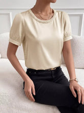 Cream-colored pearl trim satin bodysuit with puffed short sleeves and decorative pearl-trim neckline