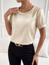 Cream-colored pearl trim satin bodysuit with a pearl-trimmed neckline and puffed short sleeves