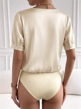 Cream-colored pearl trim satin bodysuit with short puffed sleeves and buttoned cuffs in trim satin material