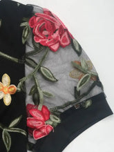 Black velvet perfee embroidered floral bodysuit with vibrant red roses and yellow blossoms on sheer gray mesh overlay