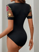 Black perfee embroidered floral bodysuit with short sleeves sheer mesh panels and embroidered v neck detailing