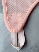 Pink mesh bra strap on pet grooming hammock for nail trimming