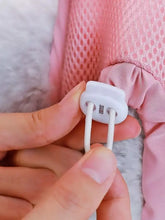 Weißer Kunststoff-Kippschalter mit elastischen Bändern an rosa Netz-Haustierpflege-Hängematten-Rückhaltesack