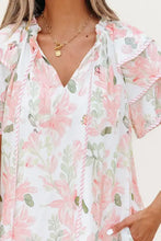 Pink and white floral print romper with ruffled hem, pockets, and short sleeves