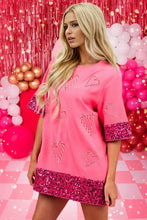 Woman in candy cane sequin half sleeve pink t-shirt dress with heart designs
