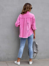 Pink distressed drop shoulder denim jacket with frayed edges and white sneakers