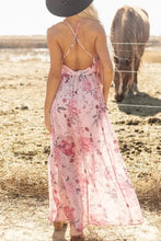 Pink floral halter neck maxi dress with crisscross back and wide-brim hat