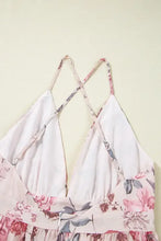 Pink floral halter neck maxi dress with crisscross back and wide-brim hat