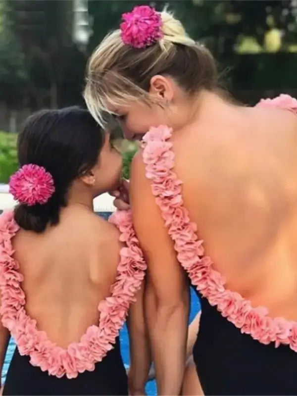 Pink floral leis on women in black dresses for stylish comfort at Hipomarket