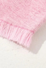 Pink lace throw with fringed floral edges on frayed denim shorts