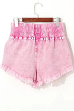 Pink frayed denim shorts with wide smocked waistband and raw hem
