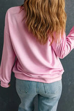 Woman in pink heart long sleeve sweatshirt and blue jeans