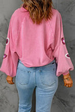 Pink heart sequin mineral wash sweatshirt with bell sleeves and jeans