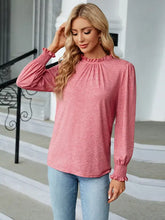Woman in round neck flounce sleeve length blouse with pink top and blue jeans