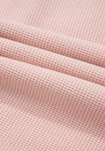 Soft pink waffle-knit blanket in oversized fleece hoodie with plaid pattern