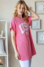 Woman in pink short sleeve ribbed top with bold USA graphic