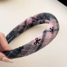 Pink and gray plaid polyester hair headband with black bow accents