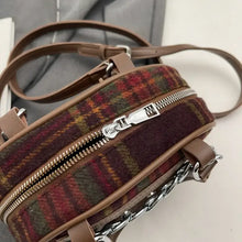 Plaid print crossbody bag with brown leather accents and silver hardware