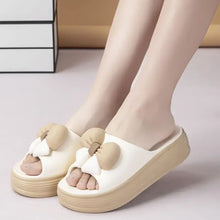 Off-white open toe platform slippers with tan bow accents for women