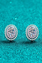 Pair of oval moissanite stud earrings with pink halo in matching box packaging
