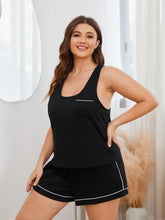 Plus size black pajama set with white contrast piping featuring a racerback tank and shorts for comfortable lounging