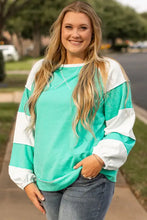 Plus size exposed seam color block sweatshirt with mint green top and dark wash jeans