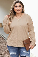 Plus size exposed seam dropped shoulder T-shirt with beige sleeves, distressed blue jeans, brown clutch