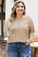 Woman in plus size exposed seam dropped shoulder T-shirt with jeans holding mug