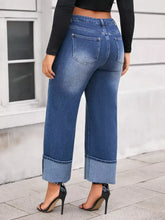 Plus size high waist blue denim jeans with wide leg design and rolled cuffs in a cuffed style