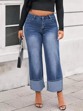 Plus size high waist wide leg blue denim jeans with rolled cuffs and a relaxed fit for casual wear
