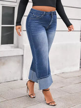Plus size high waist wide leg jeans in faded blue denim with rolled cuffs and a relaxed fit