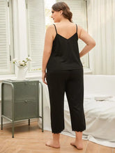 Plus size black satin camisole with lace trim and matching cropped pants pajama set for comfortable loungewear