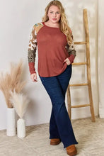 Plus size leopard waffle-knit blouse with rust tones and navy flare jeans