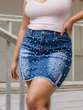 Plus size pearl embellished blue denim skirt with white pearl studs and frayed hem in a mini silhouette
