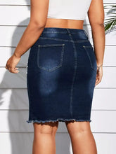 Dark blue plus size denim skirt with back pockets and pearl embellished frayed hem detail visible from the back side