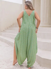 Plus size printed wide leg jumpsuit in flowing green with geometric pattern and deep v-back