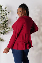 Plus size red long sleeve button ruffle hem blouse with bell sleeves and gold hoop earrings