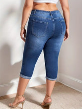 Plus size blue denim capri jeans with high waist and rolled hem cuffs in a casual style