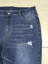 Plus size slim fit distressed jeans in dark blue denim with intentional distressing and frayed patches on the thighs